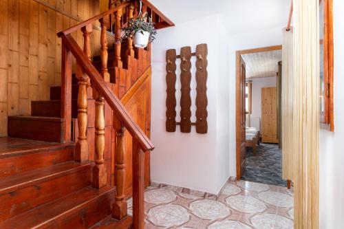 a hallway with a wooden staircase in a house at Casa de Vacanta Cascada in Vidra