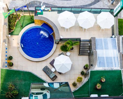 an overhead view of a pool with tables and umbrellas at Hotel Golden Park Recife Boa Viagem in Recife