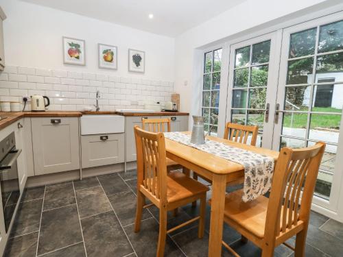 a kitchen with a wooden table and chairs in a kitchen at Craig Mawr in Benllech