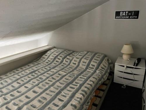 uma cama num quarto com uma placa na parede em Studio vue mer en Centre-Ville em Dinard