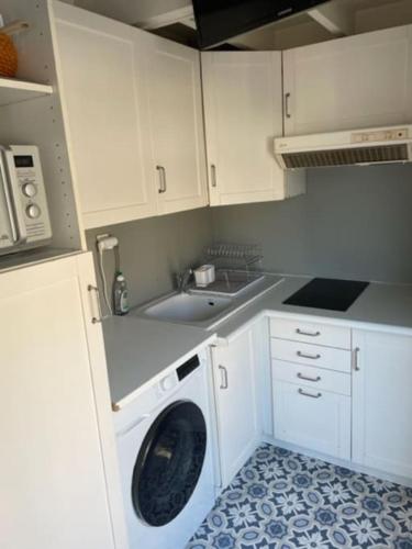 uma cozinha com uma máquina de lavar roupa e um lavatório em Studio vue mer en Centre-Ville em Dinard