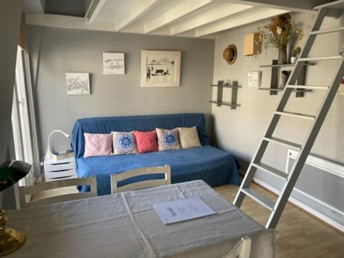 uma sala de estar com um sofá azul e uma escada em Studio vue mer en Centre-Ville em Dinard