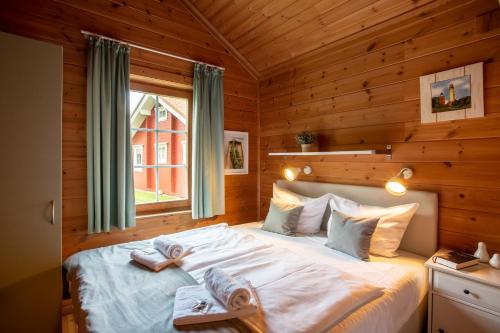 a bedroom with a bed in a wooden cabin at Typ D "Gorch Fock" -Schärenhaus- in Pelzerhaken