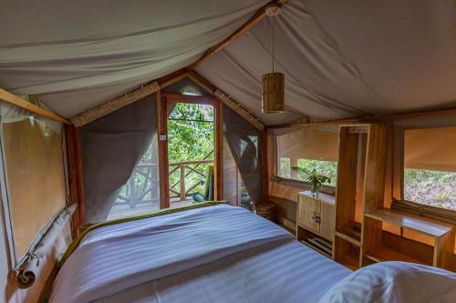 Ruhondo的住宿－Ruhondo Island Retreat，帐篷内一间卧室,配有一张大床
