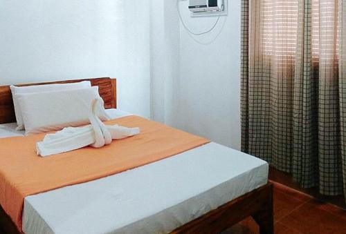 um quarto com uma cama com toalhas em RedDoorz @ Reana Seaside Pensione House Guindulman em Guindulman