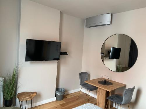 a living room with a mirror and a table and chairs at Goodnight Leuven - Self check-in with airco in Leuven