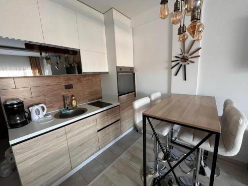 een keuken met een wastafel en een tafel met stoelen bij Milmari boutique apartment S4 in Kopaonik