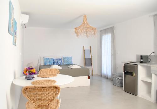 a white living room with a table and chairs at Sunrise View Lefkes in Lefkes