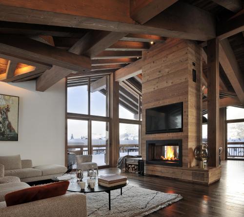 un soggiorno con camino e TV di Chalet Le Moulin, Courchevel Le Praz, 6 chambres, Ski in, Ski out a Courchevel