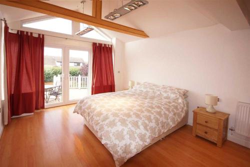 ein Schlafzimmer mit einem Bett und einem großen Fenster in der Unterkunft Whitecaps in Llandudno