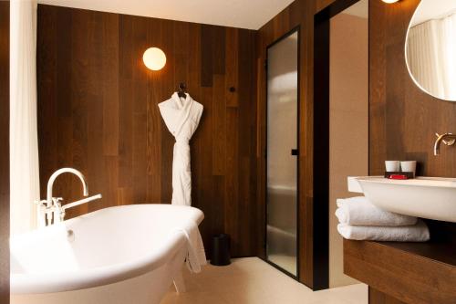 Hôtel Bourg Tibourg في باريس: حمام مع حوض استحمام ومغسلة