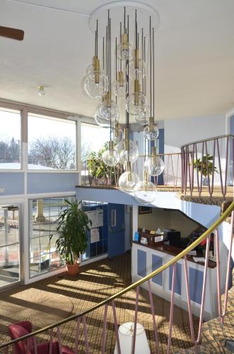 a room with a staircase with a chandelier at Red Carpet Inn & Suites Ebensburg in Ebensburg