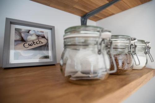 a group of jars sitting on a counter next to a picture at Cwtch, cozy studio, private, separate entrance. in Cardiff