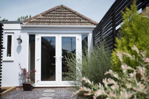 a white door on a white house at Cwtch, cozy studio, private, separate entrance. in Cardiff