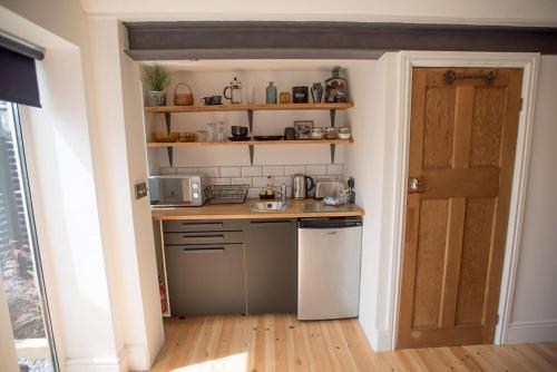 a small kitchen with a sink and a counter at Cwtch, cozy studio, private, separate entrance. in Cardiff
