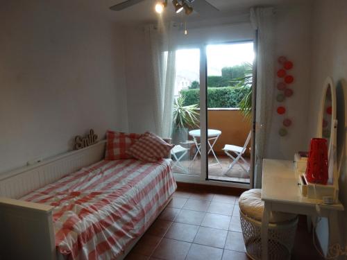 a bedroom with a bed and a balcony with a table at Casa Alcaidesa in La Alcaidesa