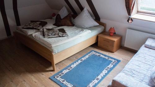 a small bedroom with a bed with a blue rug at Ferienwohnung Petersen-Kröger in Gelting