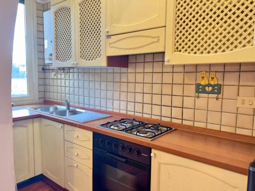 a kitchen with white cabinets and a black stove top oven at Appartme Morazzone 7 in Milan