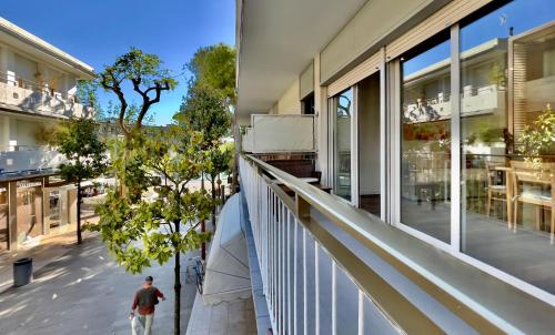 un hombre caminando en un balcón de un edificio en Monaco Apartments, en Lignano Sabbiadoro