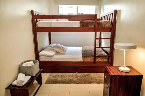 two bunk beds in a room with a desk and a lamp at DEPARTAMENTO, a una calle de la PLAYA Y MALECÓN in Salinas