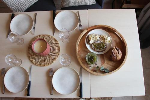 stół z talerzami żywności, widelcami i łyżkami w obiekcie Cocon face à la mer w mieście Plérin
