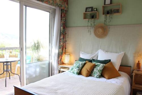 Cocon face à la mer في بليران: غرفة نوم بسرير ومخدات وشرفة