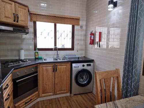 a kitchen with a sink and a washing machine at Drake Seaside Studio Apartments in Bel Ombre