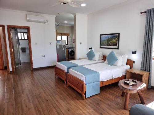 a hotel room with a bed and a table at Drake Seaside Studio Apartments in Bel Ombre
