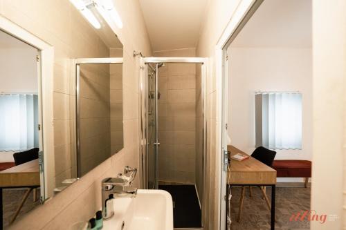 a bathroom with a shower and a sink and a mirror at A modern Maltese townhouse in Siggiewi in Siġġiewi