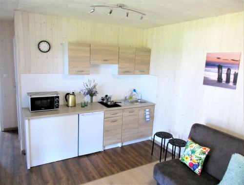 a kitchen with a couch and a microwave in a room at Domki Selma in Władysławowo