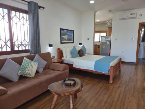 a living room with a bed and a couch at Drake Seaside Studio Apartments in Bel Ombre