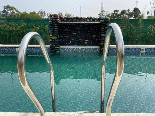 a swimming pool with two metal gates in the water at Golpo Katha in Lataguri