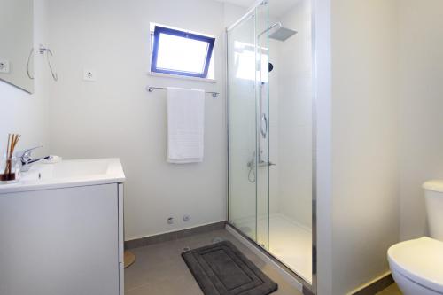 uma casa de banho com um chuveiro e um lavatório. em Apartamento Gulbenkian em Faro