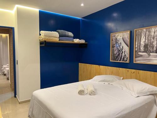 Un dormitorio azul con una cama con zapatillas. en Copacabana Diversão Garantida, en Río de Janeiro
