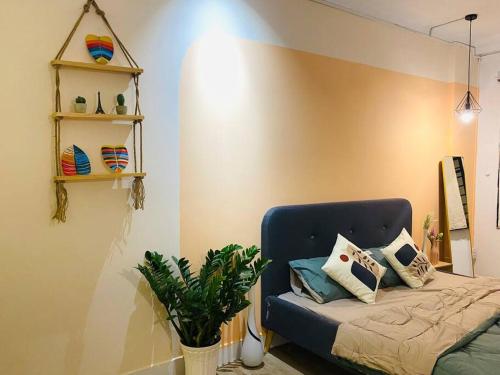 a bedroom with a bed and a plant and shelves at Studio Lagom 16, độc đáo và yên bình, kế bên dinh độc lập, nhà thờ Đức Bà ,đường Nguyễn du, phường Bến nghé, quận 1 in Ho Chi Minh City