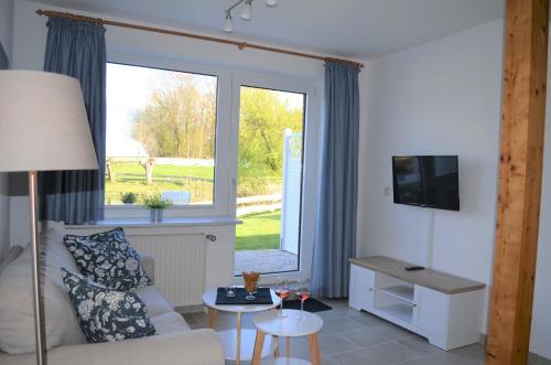 ein Wohnzimmer mit einem Sofa und einem Fenster in der Unterkunft Ferienhof Felix in Scharbeutz