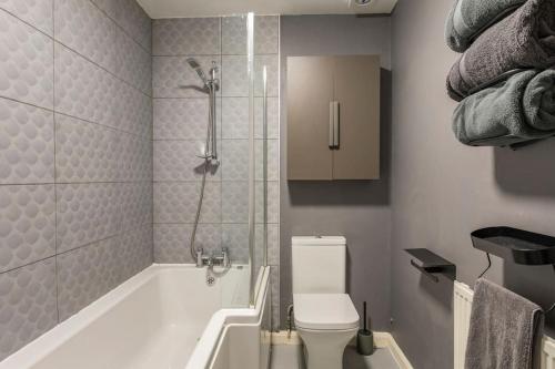 a bathroom with a shower and a toilet and a tub at Southcliff Retreat in Scarborough