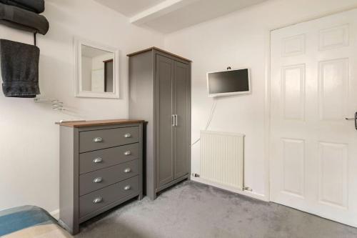 a bedroom with a dresser and a tv on a wall at Southcliff Retreat in Scarborough