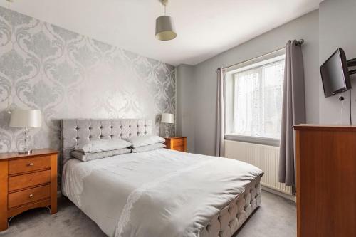 a bedroom with a white bed and a window at Southcliff Retreat in Scarborough