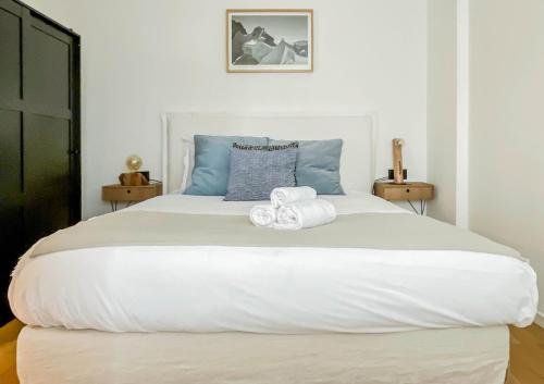 ein Schlafzimmer mit einem großen weißen Bett mit Handtüchern darauf in der Unterkunft Albatros in Annecy