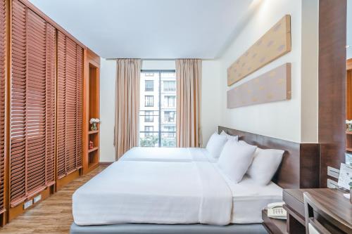 a bedroom with a bed and a large window at Amanta Hotel & Residence Ratchada in Bangkok