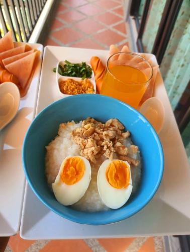 a blue bowl with eggs on top of a table at Areeya phubeach resort wooden house Coliving Coworking in Ban Chong Phli