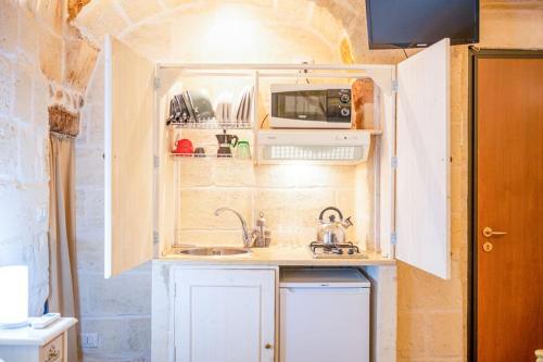 a small kitchen with a sink and a microwave at [Borgo Antico-Centro Storico] Casa Ventosa in Oria