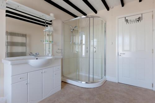 a bathroom with a glass shower and a sink at King Arthurs Arms in Tintagel