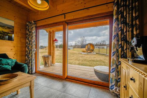 a room with a large glass window in a cabin at Rusiński Wypas Bukowina Tatrzańska - apartament i dwa domki z pięknymi widokami, zewnętrzną sauną i przestronnym parkingiem w cenie in Bukowina Tatrzańska