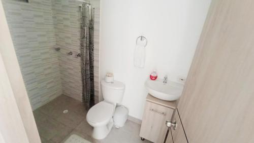 La salle de bains est pourvue de toilettes, d'un lavabo et d'une douche. dans l'établissement Fresco y Cómodo Apartamento En Aqualina Orange Girardot, à Girardot