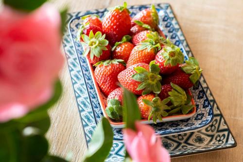 a bowl of strawberries on a plate on a table at Residence Casa e Vela in Oggebbio