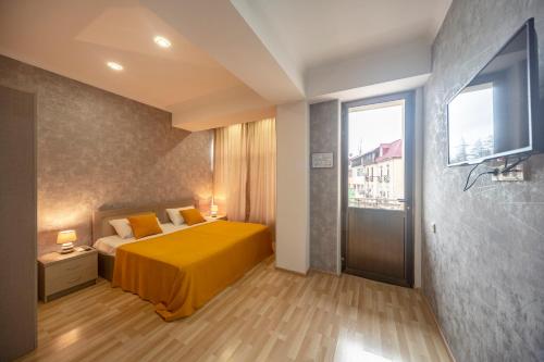 um quarto com uma cama amarela e uma janela em Tskaltubo Hotel Terrace em Tskaltubo