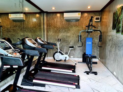 un gimnasio con 2 bicicletas estáticas y una cinta de correr en Areeya phubeach resort wooden house, en Ban Chong Phli