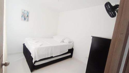 - une chambre avec un lit doté d'un couvre-lit blanc dans l'établissement Fresco y Cómodo Apartamento En Aqualina Orange Girardot, à Girardot